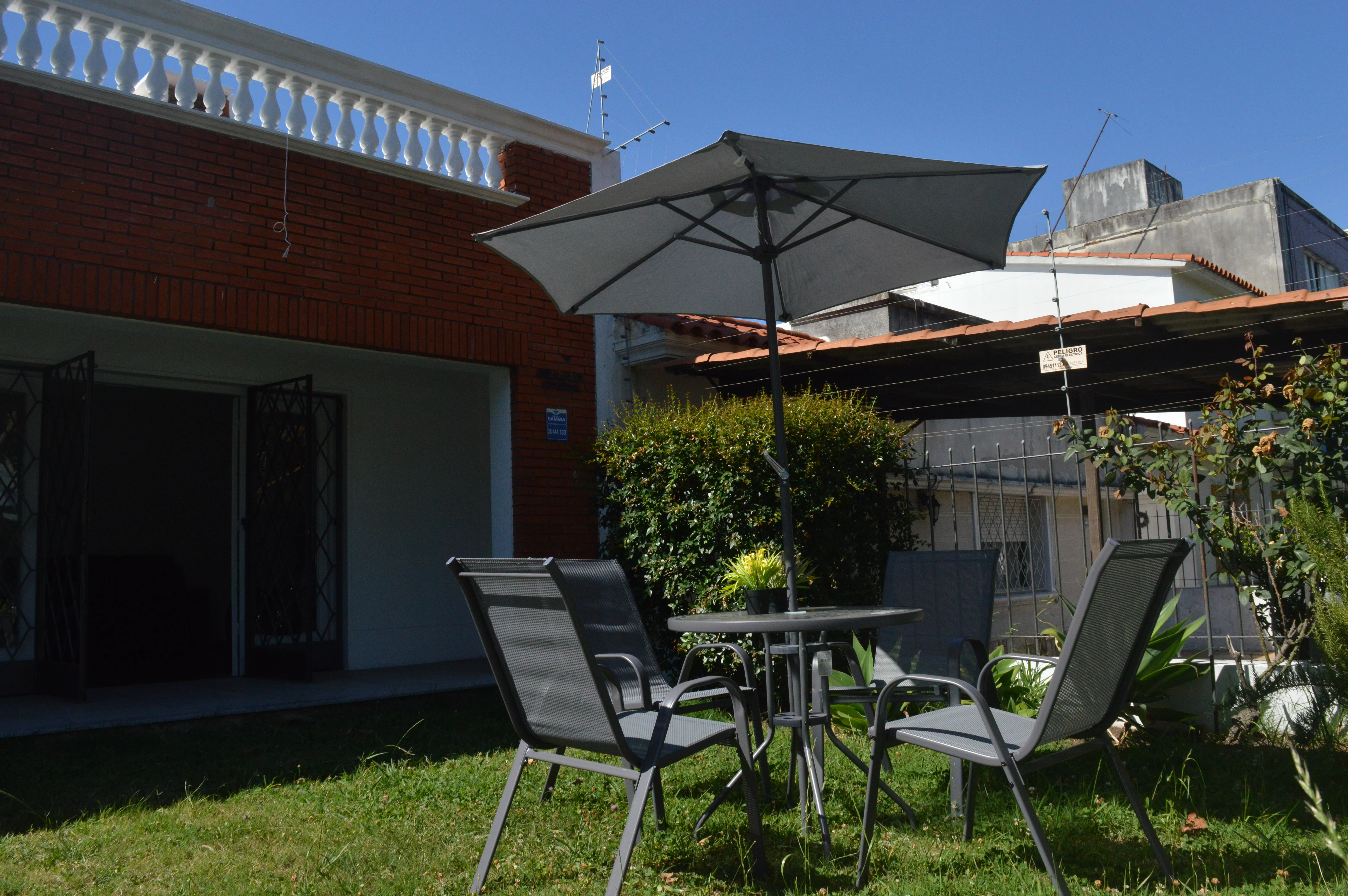 Patio exterior con mobiliario y sombrilla del Residencial Lumina