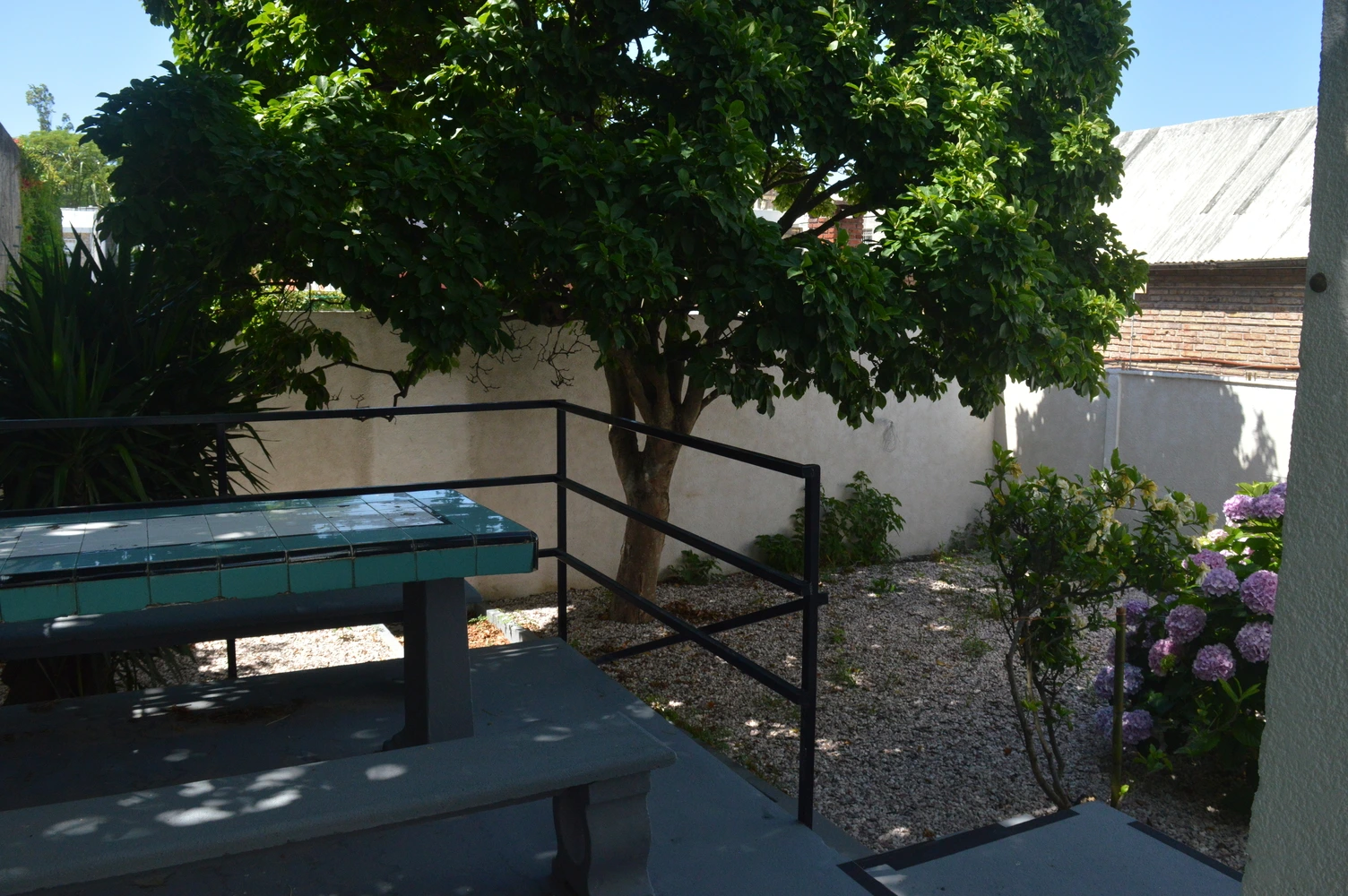 Patio exterior con mobiliario y jardín del Residencial Lumina